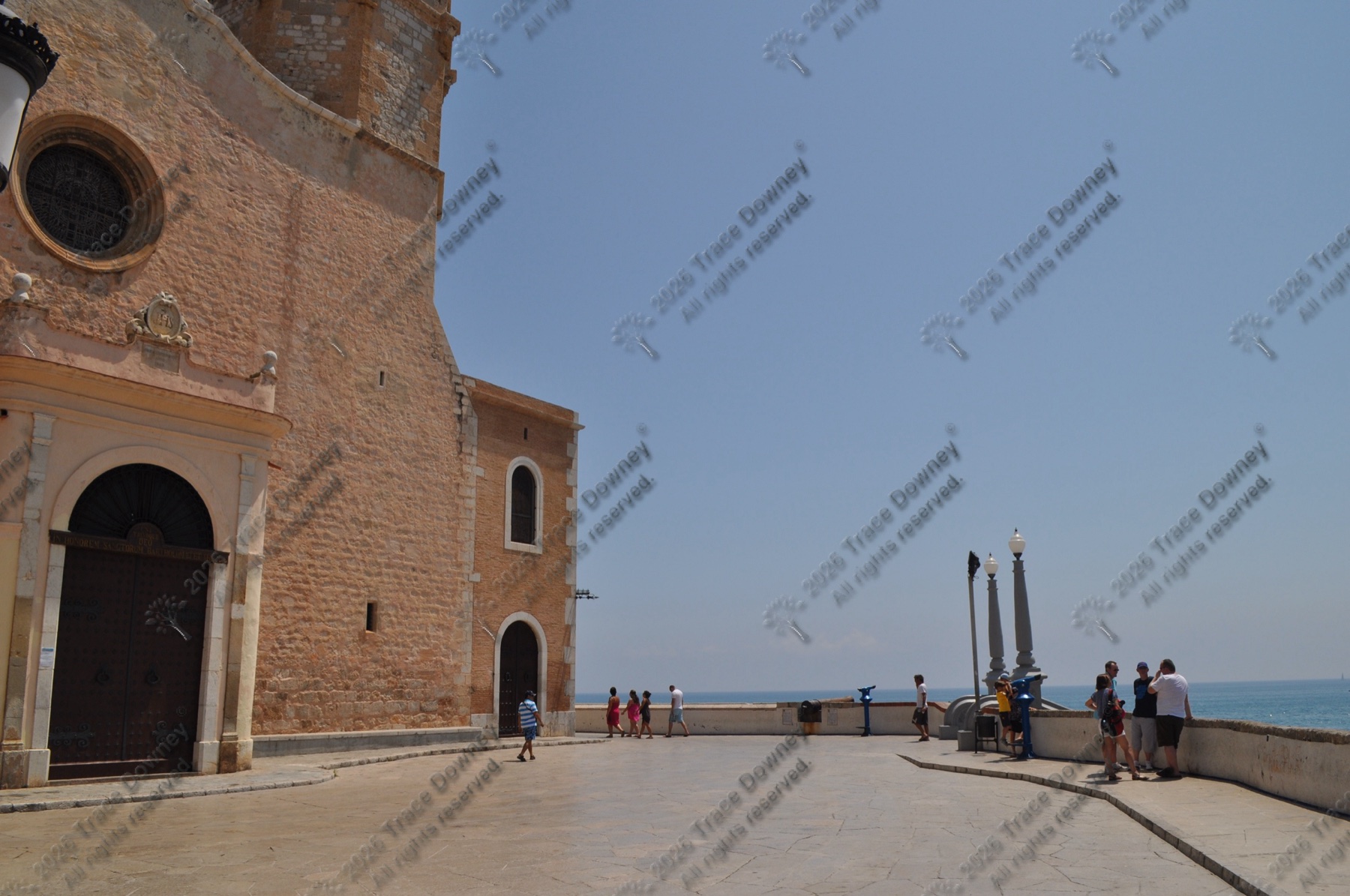 Historic church facade facing the sea at the edge of a bright coastal square.