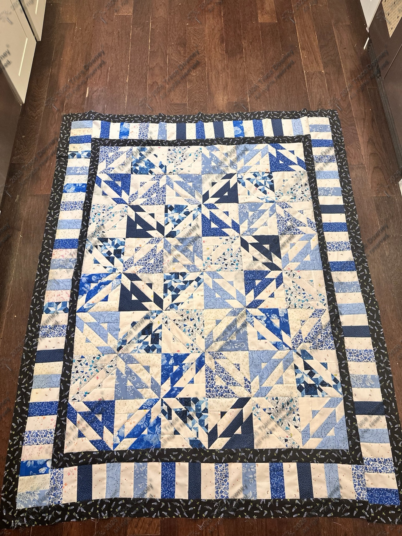 Blue and white quilt runner with long diamond-based piecing.