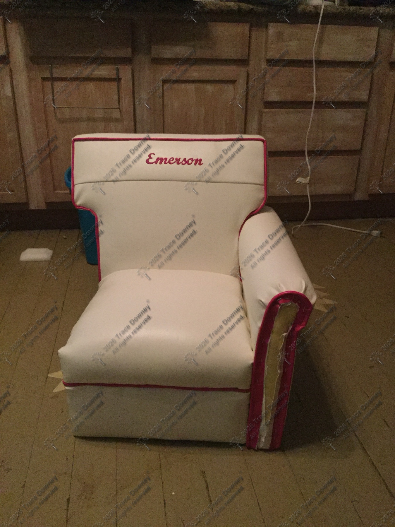 White chair with red trim before restoration, photographed in a workshop setting.