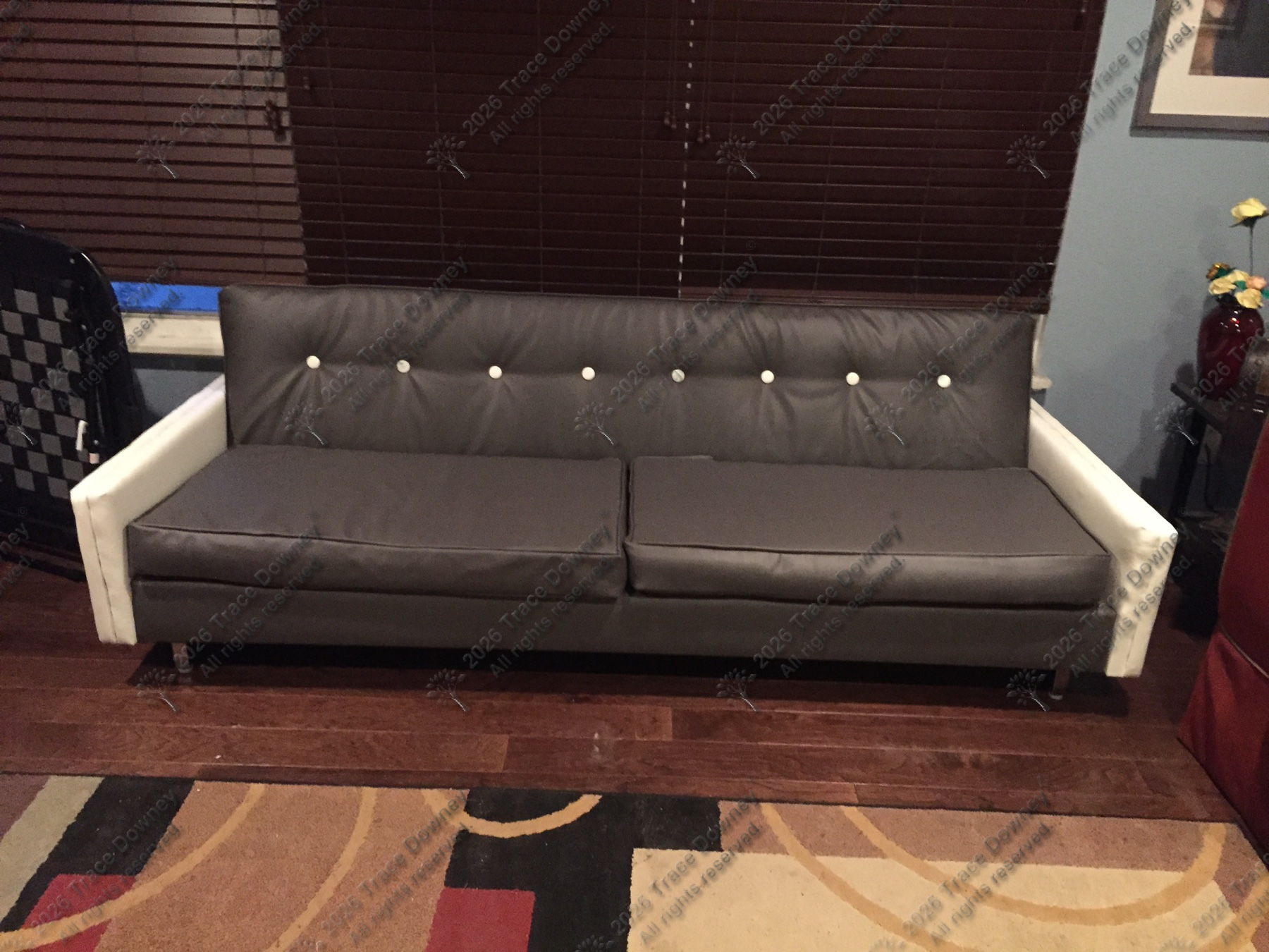 Finished gray tufted tuxedo sofa with light upholstered arms.