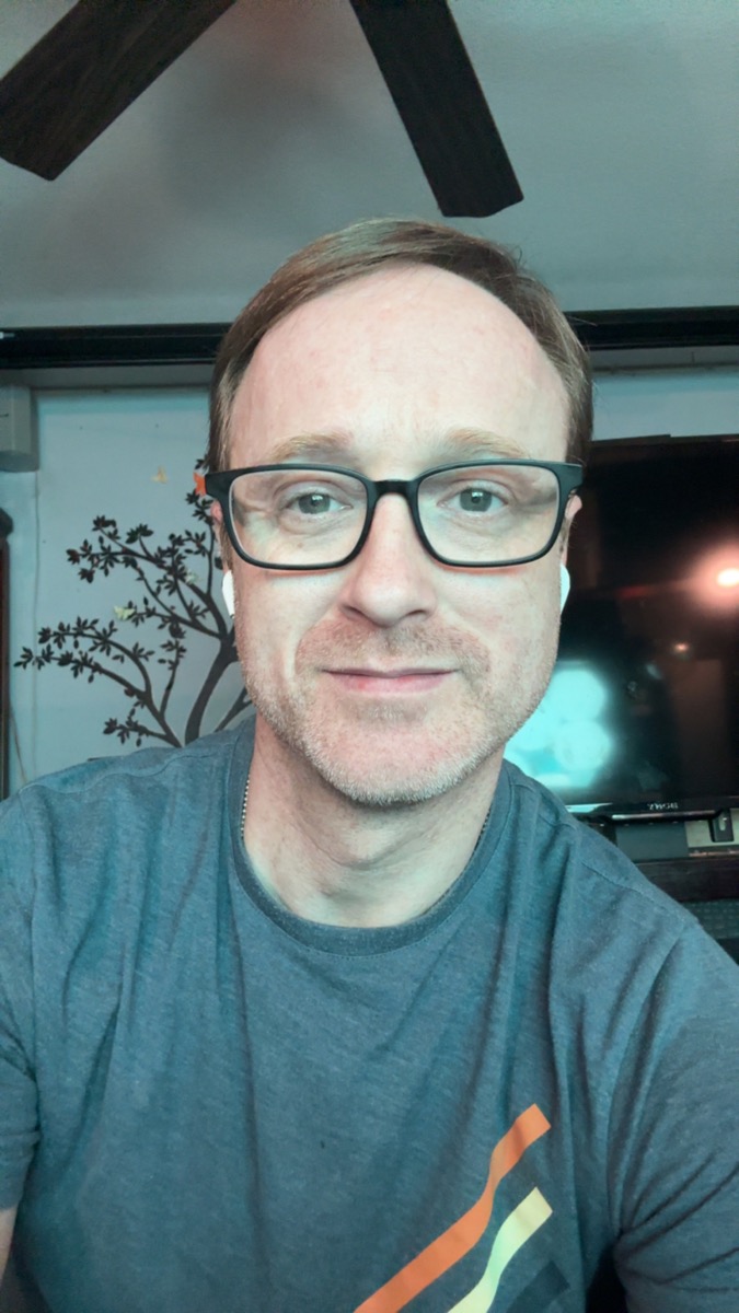 Trace Downey smiling in a casual portrait.